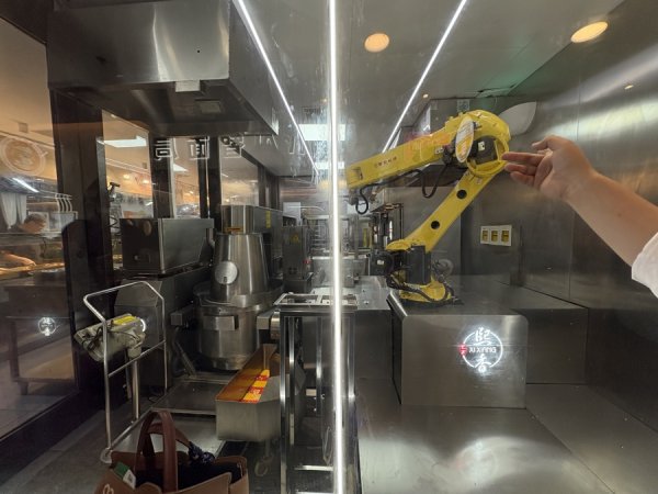 新富策略 机器人炒菜亮了！全国首家社区AI食堂背后藏着什么样的金融暖服务？